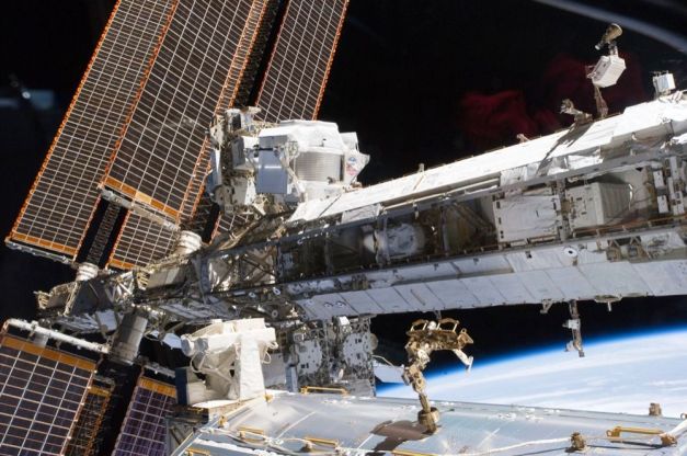 AMS-02 (devant les panneaux solaires, en haut) est installé sur la Station spatiale internationale (ISS). Il chasse la matière noire depuis presque quatre ans et devrait encore le faire pendant plusieurs années. © Nasa
